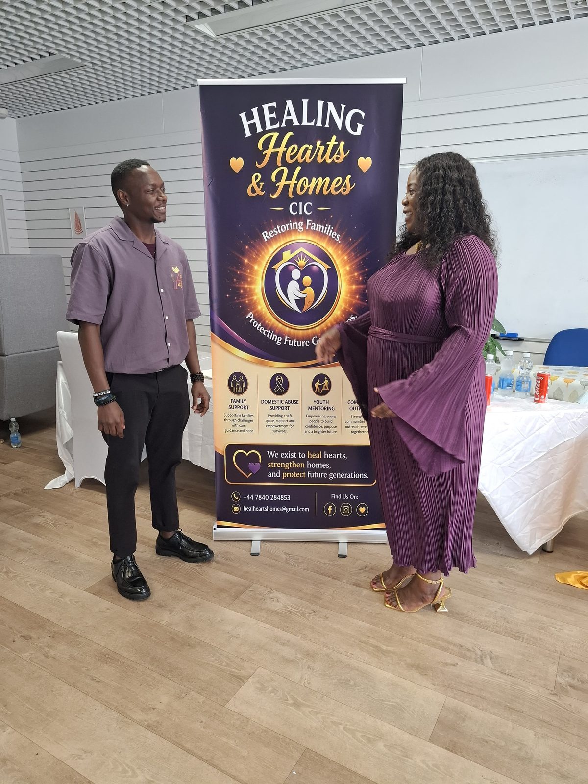 Team member sharing the Healing Hearts & Homes CIC mission with a guest at the launch