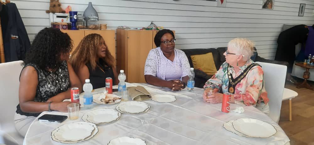 Guests seated around a table in conversation at the Healing Hearts & Homes CIC launch