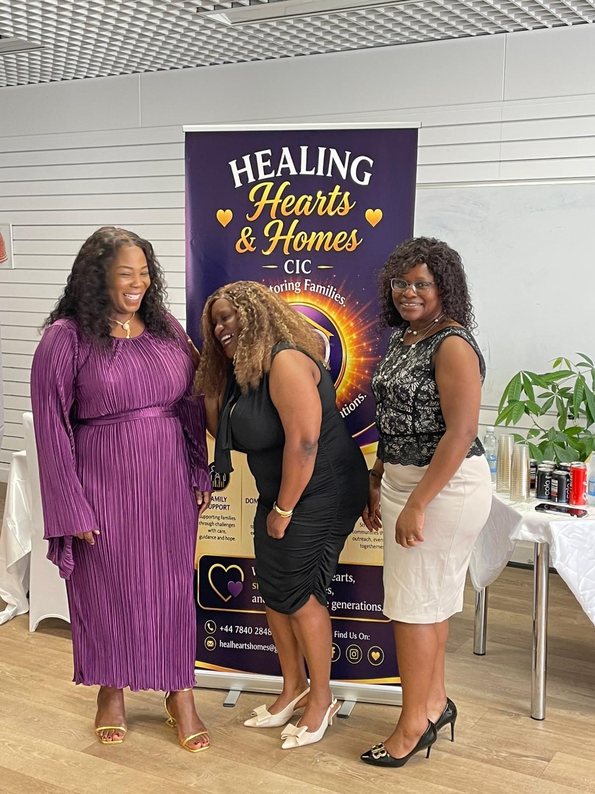 Team members sharing a joyful moment at the Healing Hearts & Homes CIC launch event
